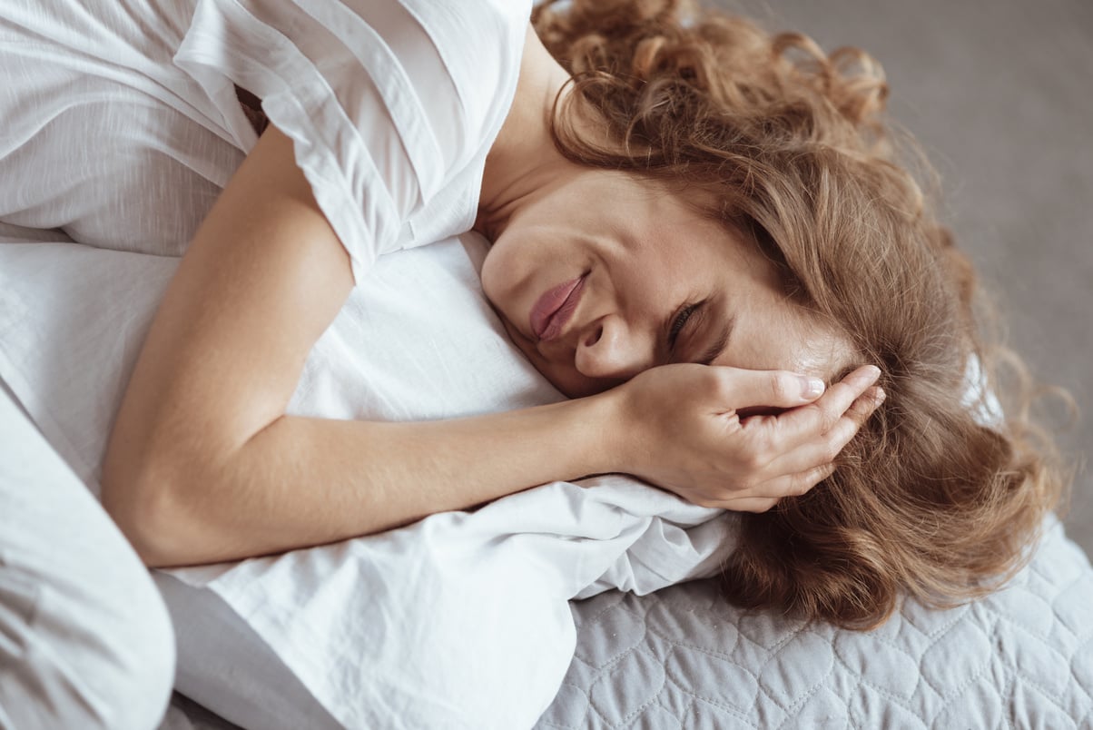 Emotionally exhausted woman crying on pillow